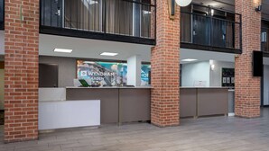 A reception area with a Wyndham Garden sign, a reception desk, and a check-in counter.
