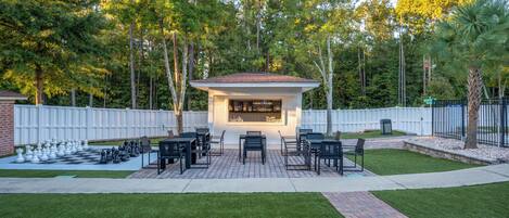 A patio area with a chessboard, outdoor seating, and a bar.