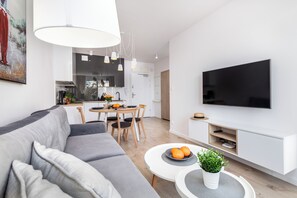 Departamento exclusivo, 1 habitación, sauna | Área de sala de estar | Televisión de plasma de 50 pulgadas con canales digitales y televisión 