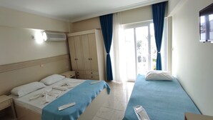 A hotel room with a bed, a desk, a wardrobe, and a window with curtains. - Afrodit Beach Otel (Kusadasi)