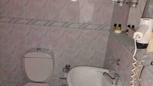 A bathroom with a toilet, sink, and hairdryer. - Afrodit Beach Otel (Kusadasi)