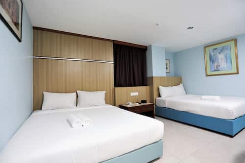 Habitación cuádruple Deluxe, vistas a la ciudad | Escritorio, tabla de planchar con plancha, wifi gratis y ropa de cama