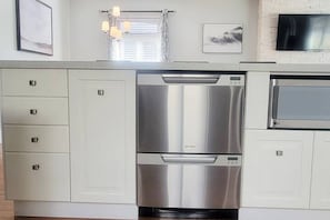 A kitchen with stainless steel appliances, white cabinetry, and a flat-screen TV mounted on the wall. - ★★Entire ★ House ★ 3 BR  ★ 5 guests (Calgary)