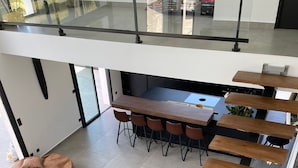 Un interior moderno con comedor, asientos y una escalera.