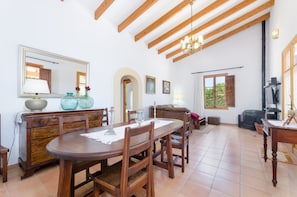 Un comedor con muebles de madera, un espejo grande y una araña.