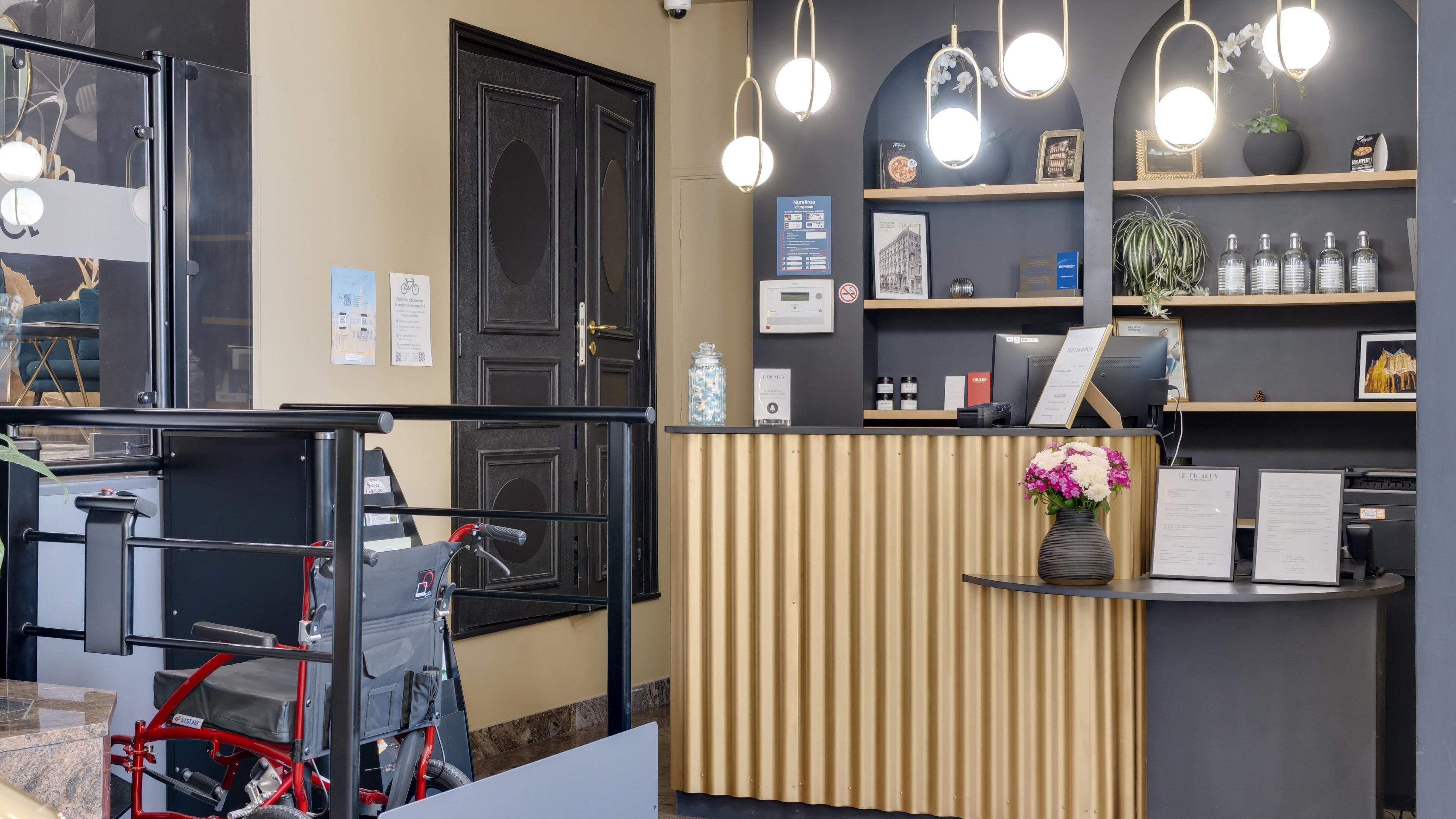 A reception area with a wooden counter, a bicycle, and a flower vase.