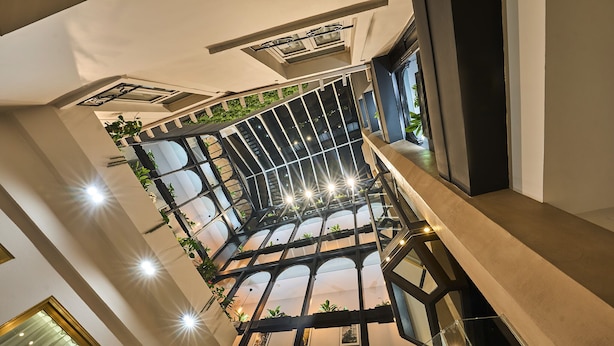 Een meerlaags interieur met een glazen atrium, modern design en kamerplanten.