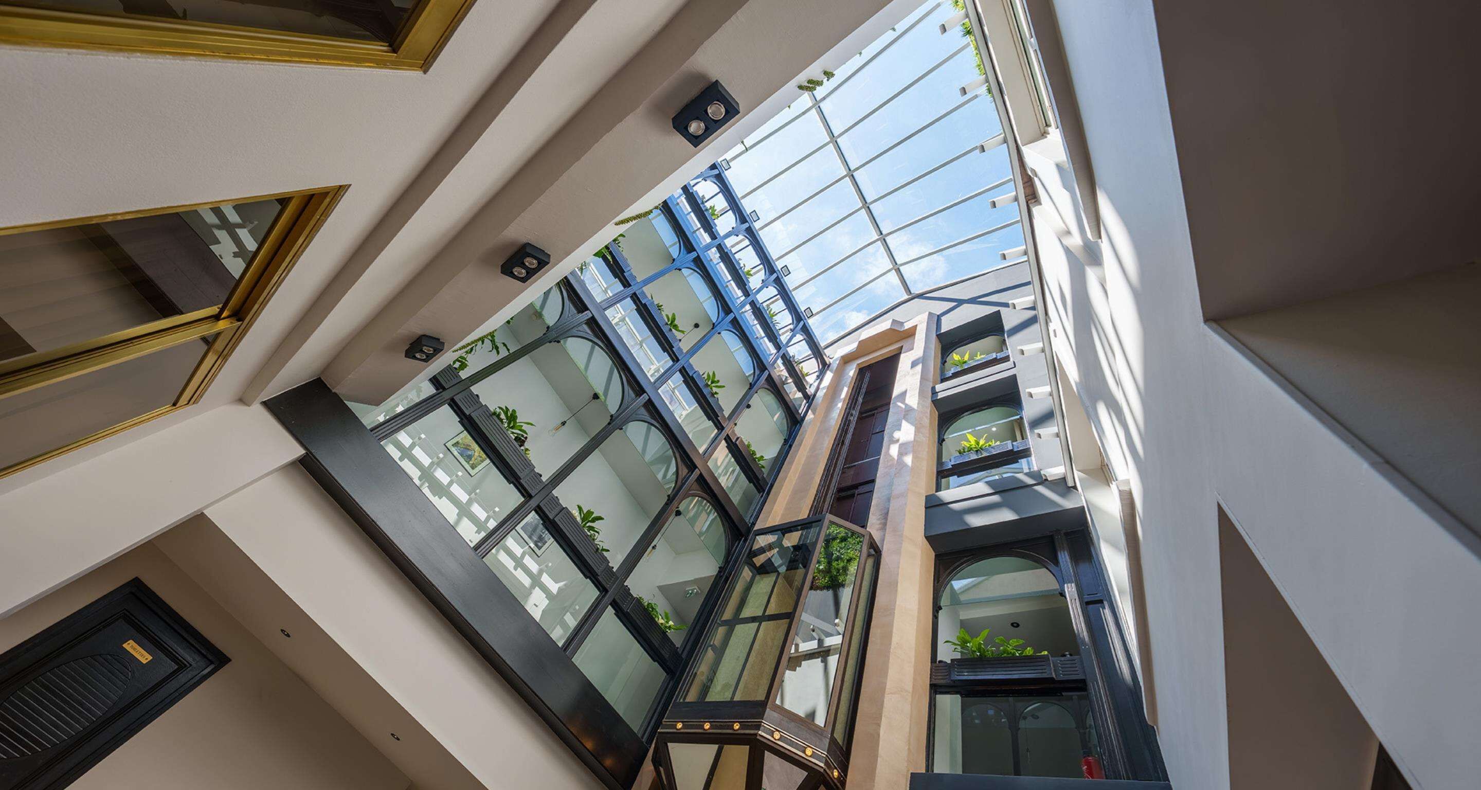 Un atrio de varios niveles con barandillas de vidrio y un diseño arquitectónico moderno.