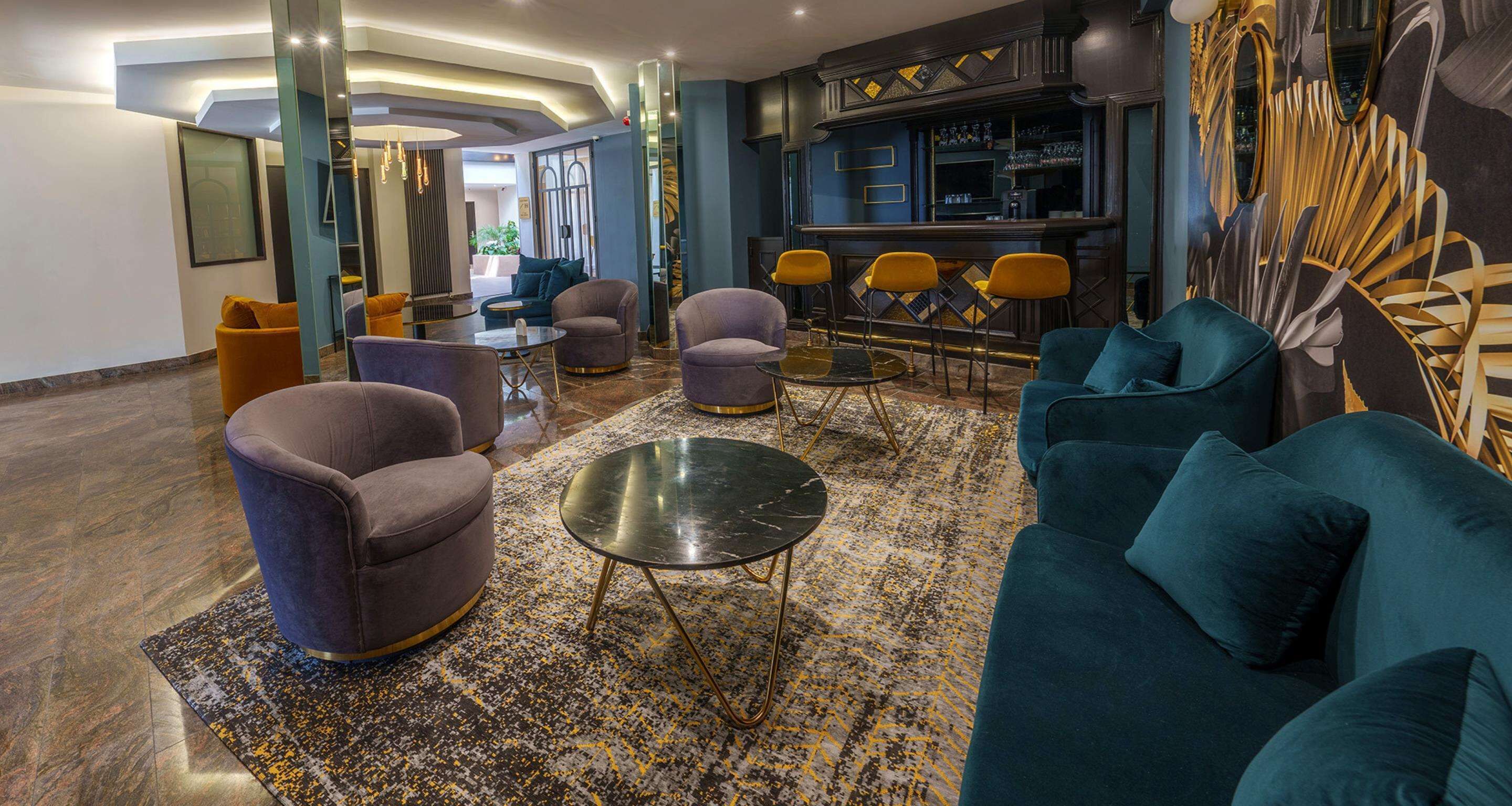 A modern lounge area with sofas, armchairs, and a bar.