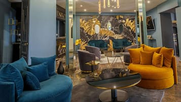 A modern lounge area with a blue sofa, a yellow sofa, and a round table.