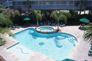 A swimming pool with multiple levels of seating and palm trees.