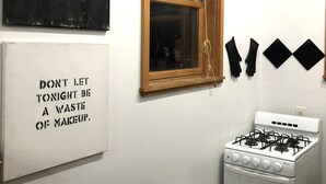 A kitchen with a stove, a window with blinds, and a wall with a motivational quote. - Studio in the Heart of East Austin (Austin)
