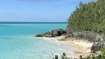 Una playa cerca, sillas reclinables de playa, toallas de playa