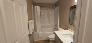 Et badeværelse med badekar, toilet og vask.