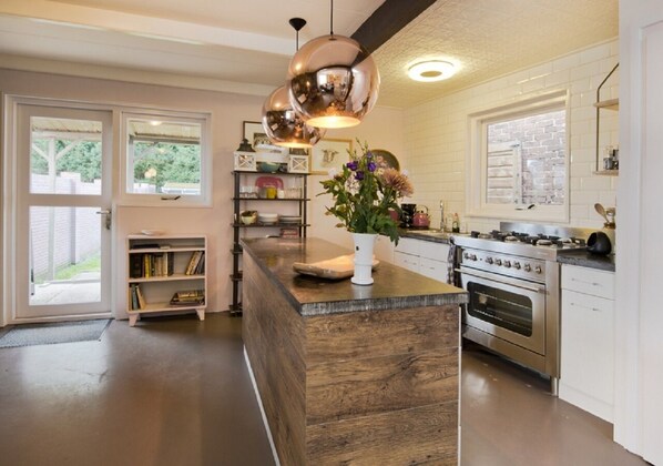 A modern kitchen with a central island, stainless steel appliances, and pendant lighting.