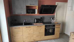 Una cocina compacta equipada con microondas, horno y lavabo.
