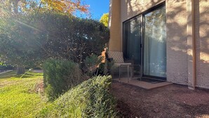 Un bâtiment moderne doté d’une porte en verre et d’un petit espace extérieur aménagé en coin salon.
