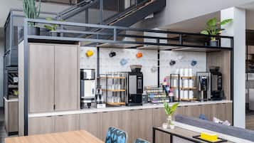 Un café moderne avec un comptoir en bois, un espace salon et un escalier.