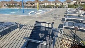 A pool area with lounge chairs and a water feature. - New Modern Home, Lakefront, Park & Pool, spacious 4br/3ba very safe place<br> (Baton Rouge)