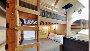 A bunk bed room with a wooden ladder, a desk with a mirror, and a wall-mounted light fixture. - Loft of Luxury by Taylor Made Deep Creek (Oakland)