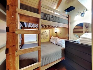 A bunk bed room with a wooden ladder, a desk with a mirror, and a wall-mounted light fixture. - Loft of Luxury by Taylor Made Deep Creek (Oakland)