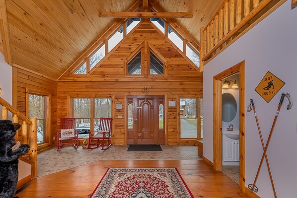 Cozy cabin-style retreat with a high ceiling, large wooden door, and ski access nearby.