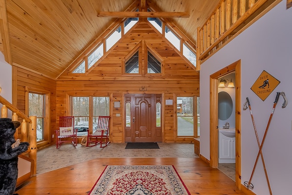 Cozy cabin-style retreat with a high ceiling, large wooden door, and ski access nearby.