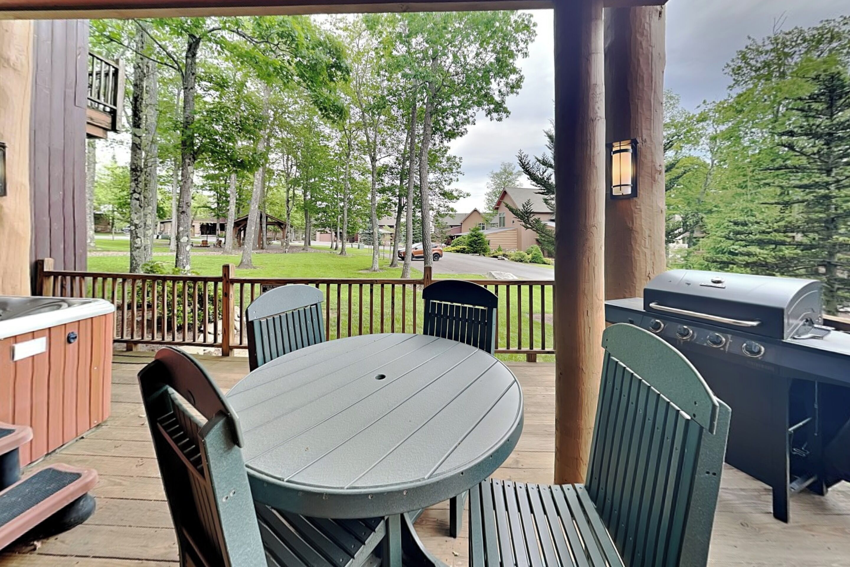 A covered outdoor area with a grill, hot tub, and seating.