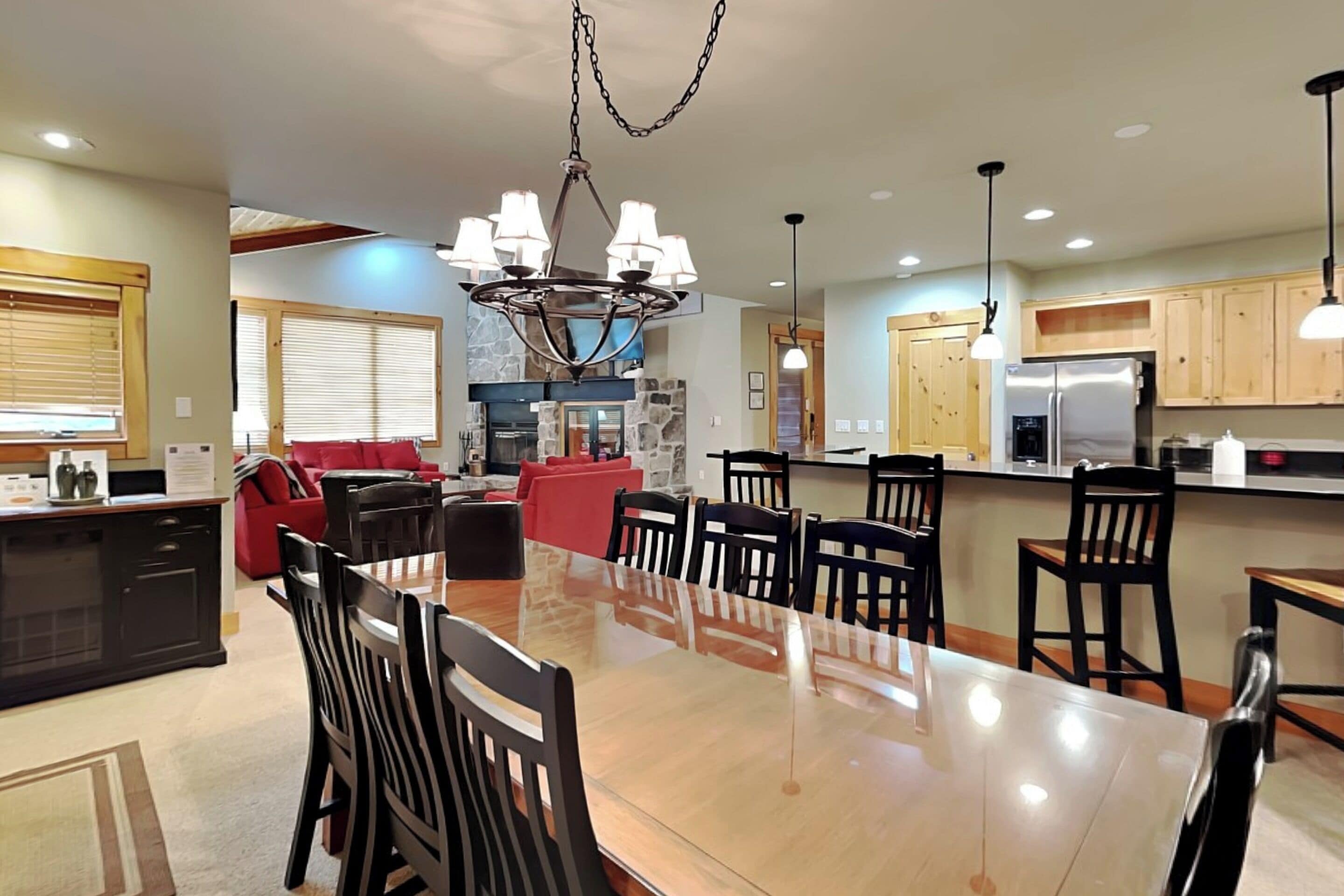 Una cocina amplia con una gran mesa de comedor, armarios de madera y una chimenea de piedra.