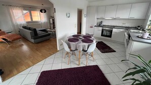 A modern apartment with a living room, dining area, and kitchen.