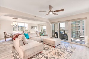 Relax in this inviting living area with a large L-shaped sofa, dining table, and chandelier.