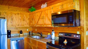 A kitchen with wooden cabinets, a stainless steel refrigerator, a microwave, and an oven. - ENCHANTED VIEW~**Super cozy & Awesome Valley Views~10 minutes to Pigeon Forge ** (Sevierville)