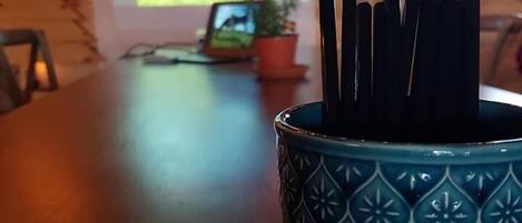A wooden cabin interior with a table displaying a laptop and a potted plant.