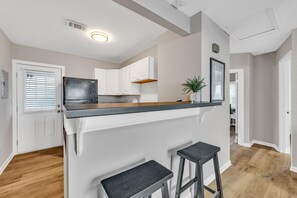 Enjoy refreshments at the bar area with two stools.