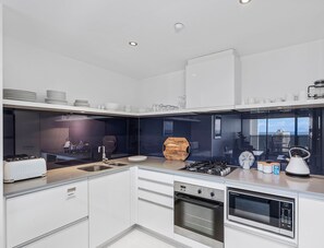 Eine moderne Küche mit Backofen, Mikrowelle und Gasherd.
