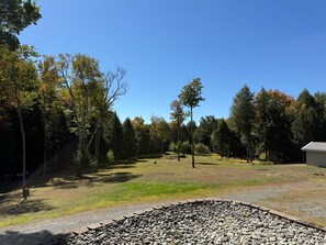 A gravel path leading through a grassy area with trees and a building in the distance.