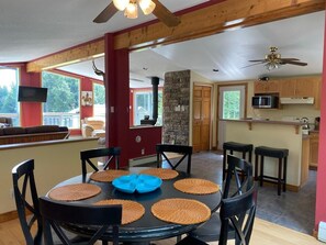 A dining area with a round table, black chairs, and woven placemats.