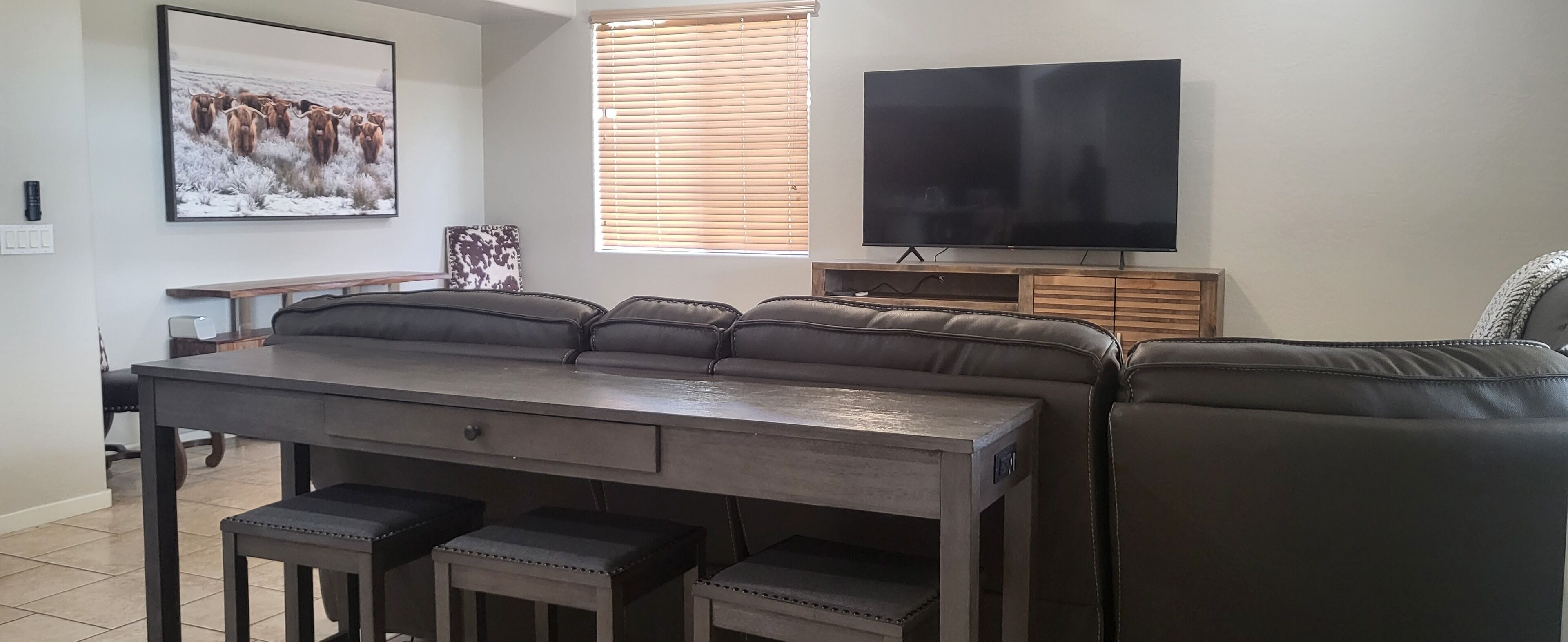Una sala de estar moderna con un sofá, una mesa de comedor y un televisor de pantalla plana.