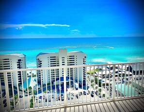 Un hôtel de grande hauteur doté de nombreux balcons offrant une vue sur une plage et l’océan.