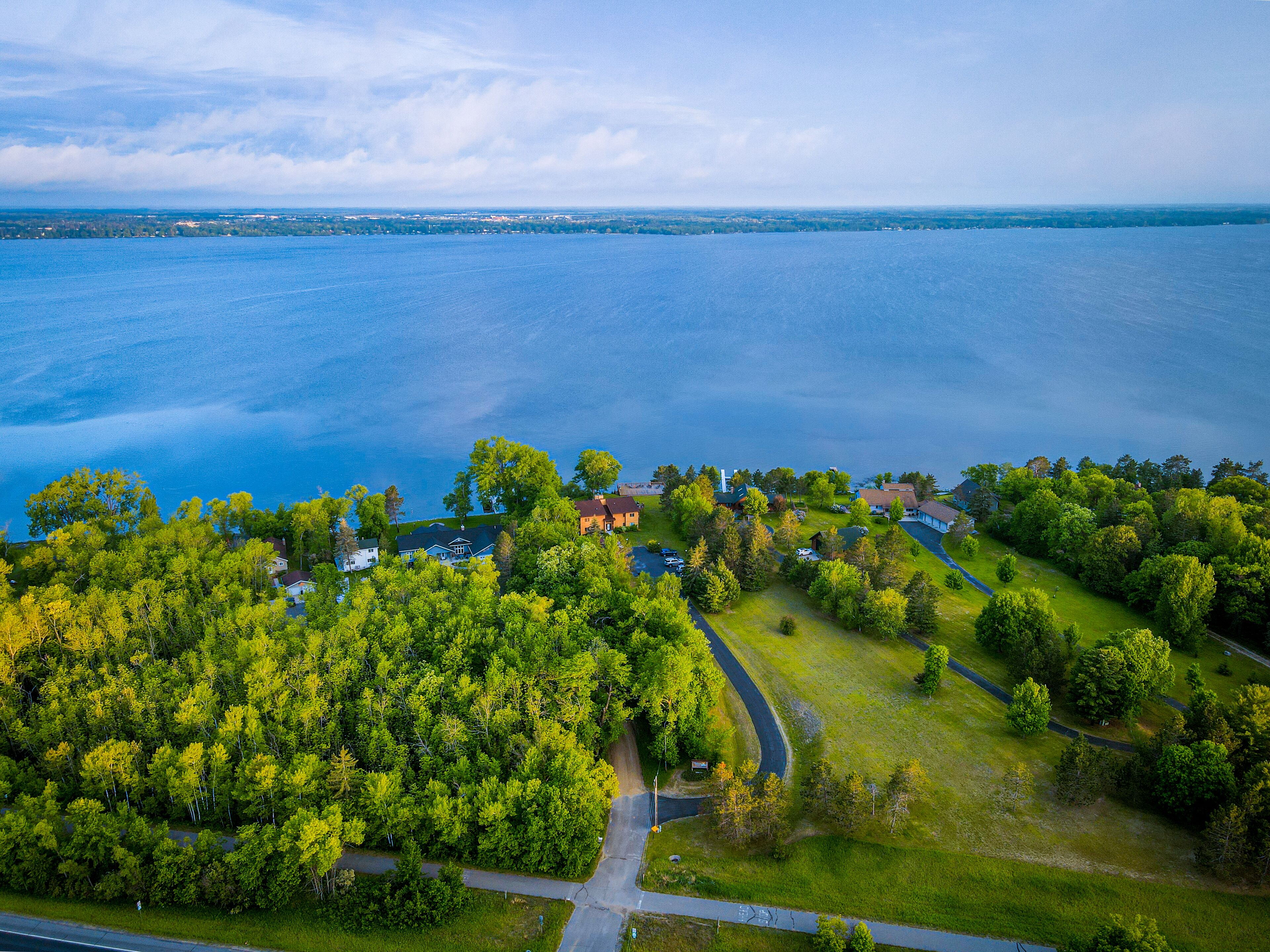 Vue aérienne d’un quartier résidentiel avec des maisons, une route et une grande étendue d’eau.