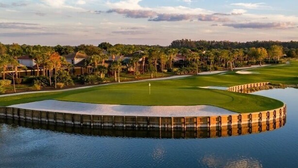 A golf course with a water hazard, surrounded by trees and houses. - First-Floor Carriage House at Colonial CC, Renovated Golf Course with Lake View (Fort Myers)