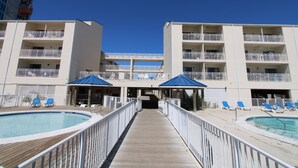 Un hôtel doté d’une piscine, de plusieurs balcons et de chaises longues.