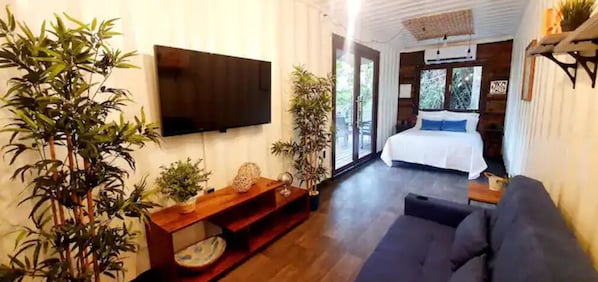 Ein modernes Wohnzimmer mit einem Flachbildfernseher, einer Couch und einer Holzunterhaltungsecke.