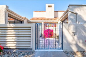 Stunning home with an entrance, light-colored exterior, and a tiled roof.