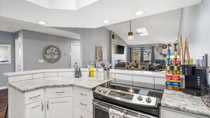 A modern kitchen with white cabinetry, a granite countertop, and a built-in oven.