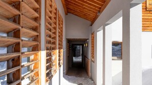 A corridor with wooden beams and a snow-covered ground.