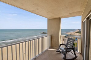 Ein Balkon mit Blick auf Strand und Meer.
