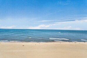 A beach with a clear sky and calm sea.