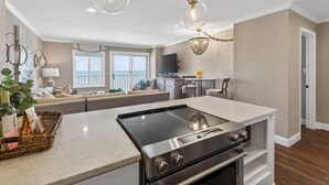 A modern kitchen with a central island, stainless steel appliances, and pendant lighting.