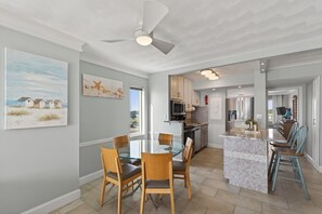 Una cocina moderna con una isla central, sillas de madera y una mesa de comedor.